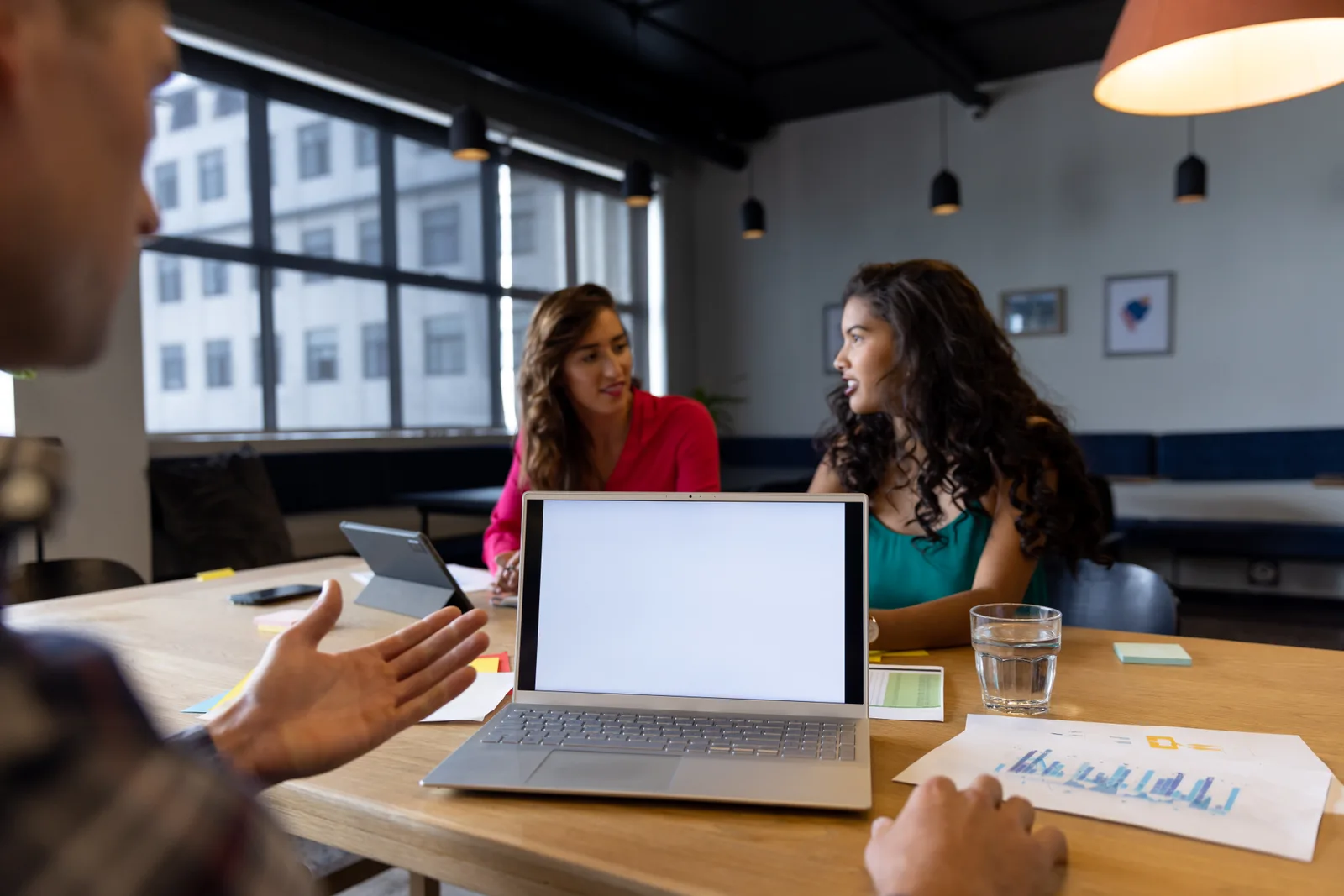 Three marketing team members around one laptop going over a monthly report together