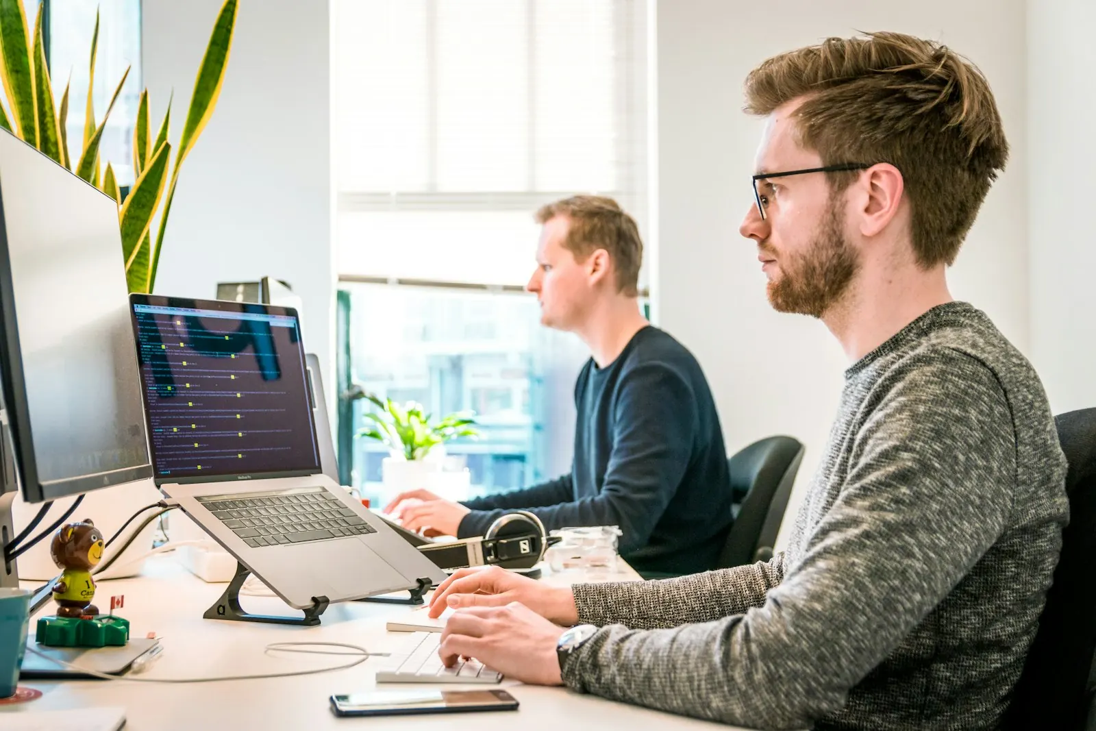 Multiple screens glowing in a dark editing workspace
