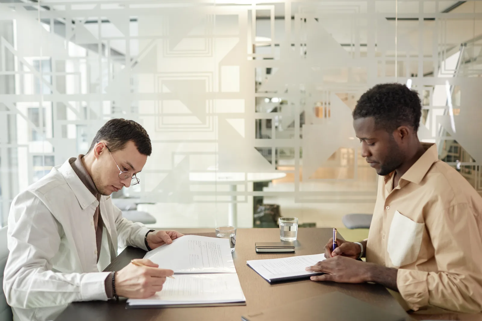Business owner going through a written checklist with two agency staff across a meeting table