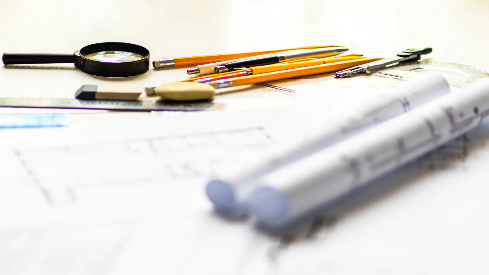 Architectural blueprints and drafting tools on a desk, representing the setup plan for a complete GoHighLevel build