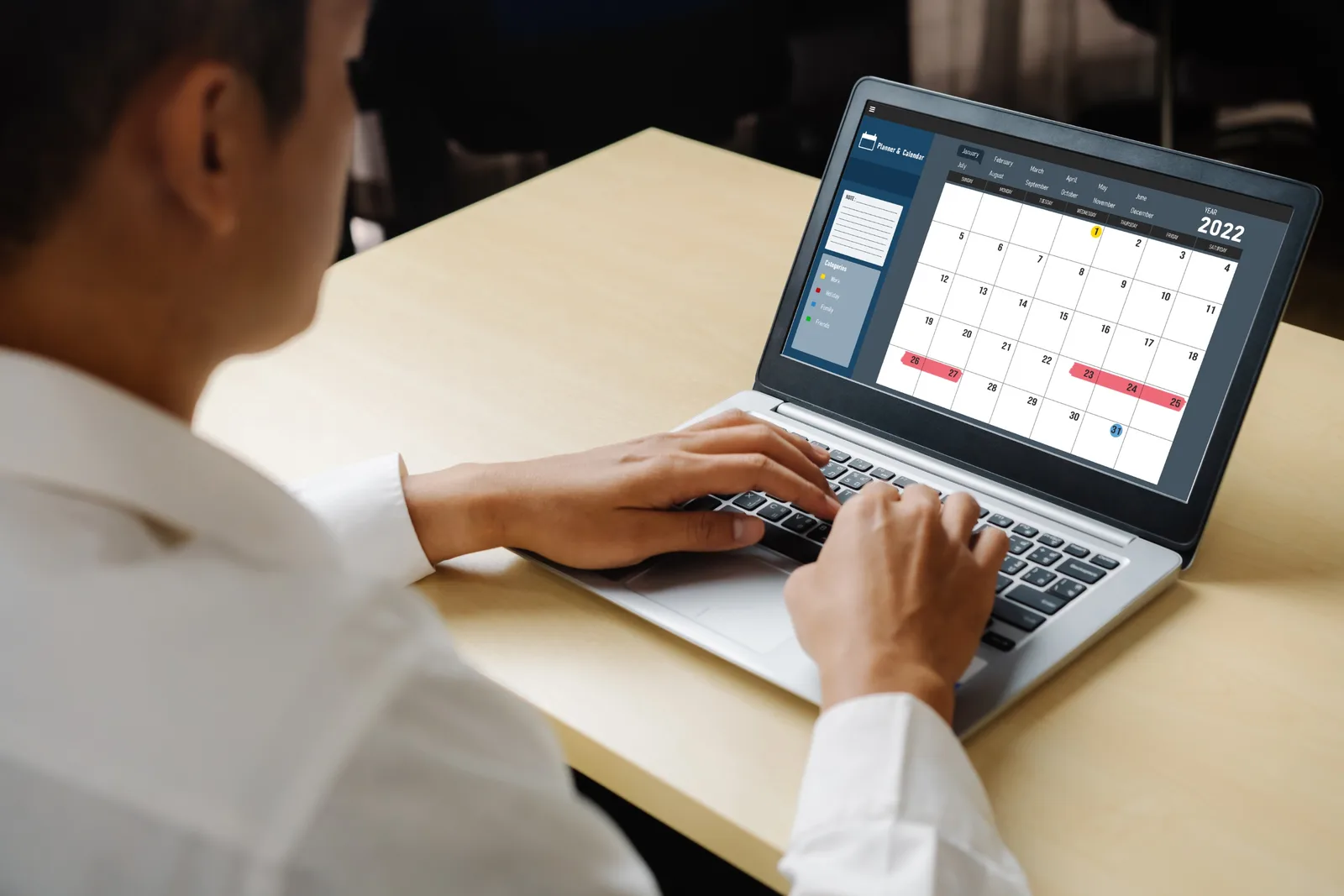 Hands at a laptop showing a calendar, counting the days a registration takes to clear
