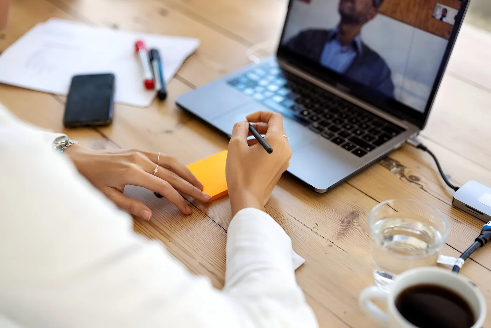 A businesswoman takes notes on a video call, the kickoff where the client's details get collected