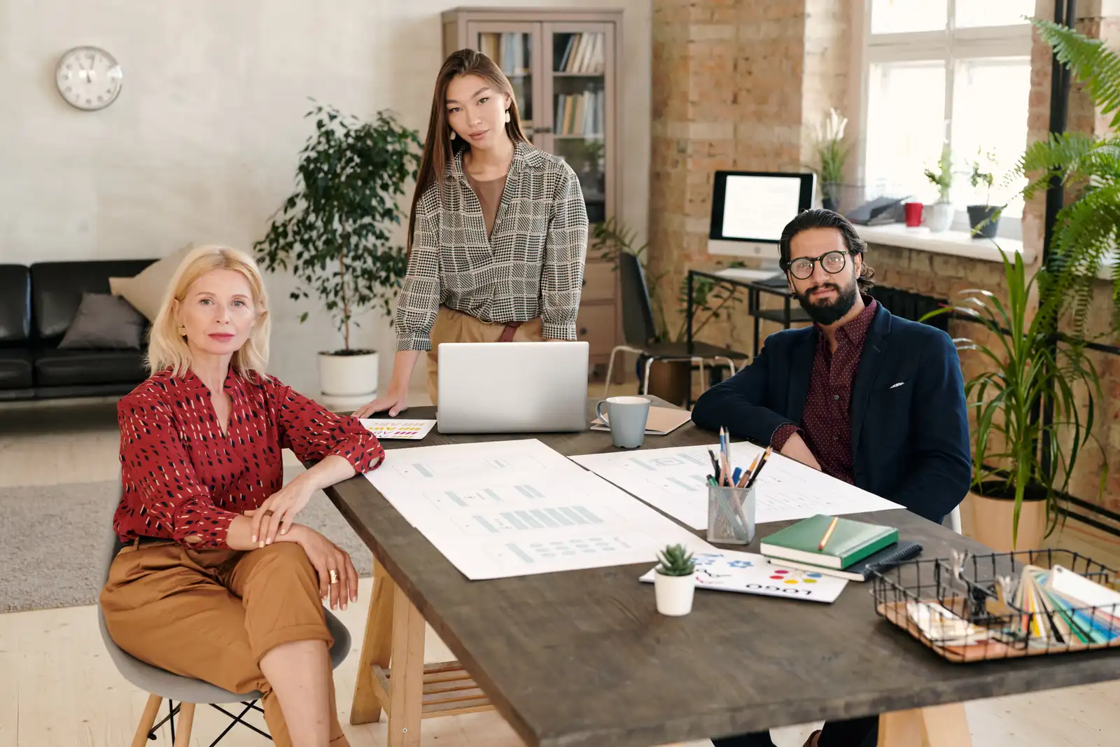 Three agents at a small brokerage go through the week's pipeline together at one desk