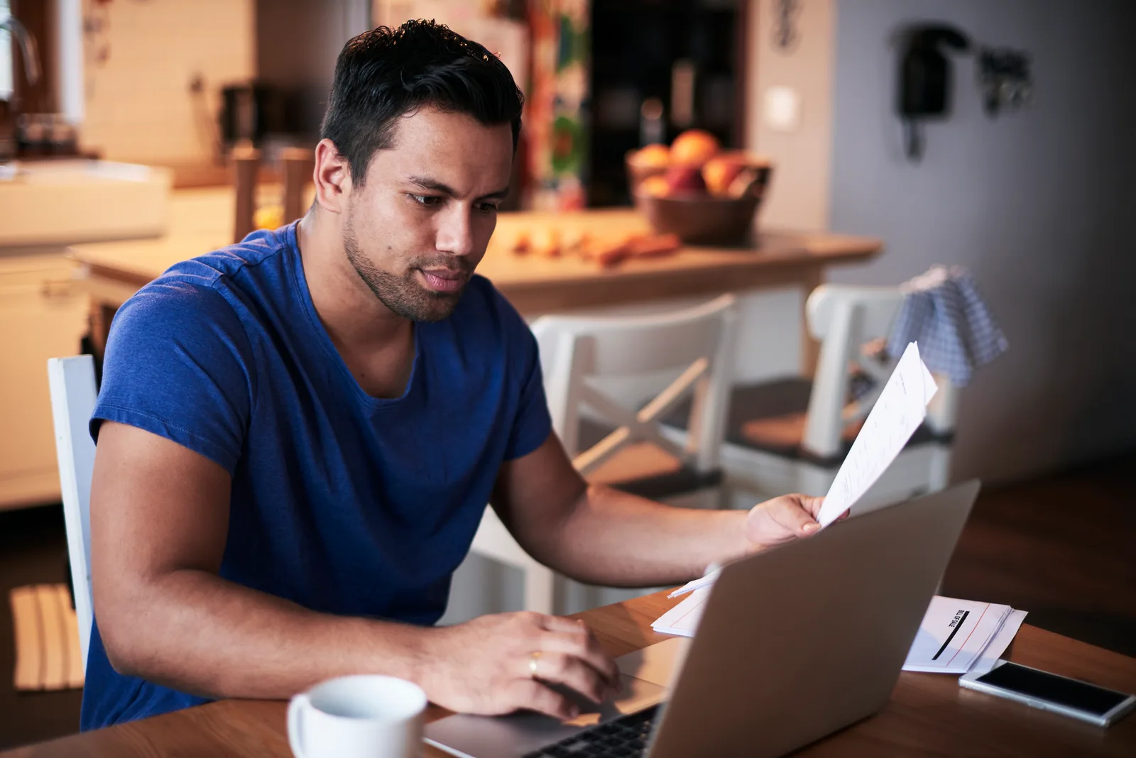 A business owner at his laptop reads a subscription bill, working out which tools still earn their fee