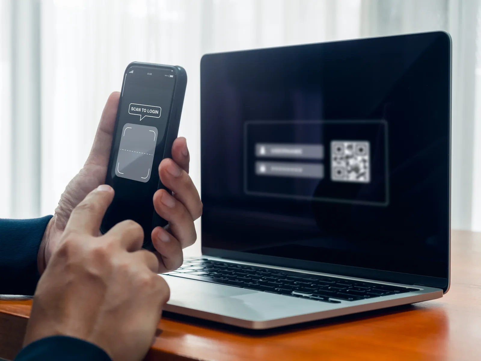 Person entering a two-factor login code from a smartphone into a laptop sign-in screen