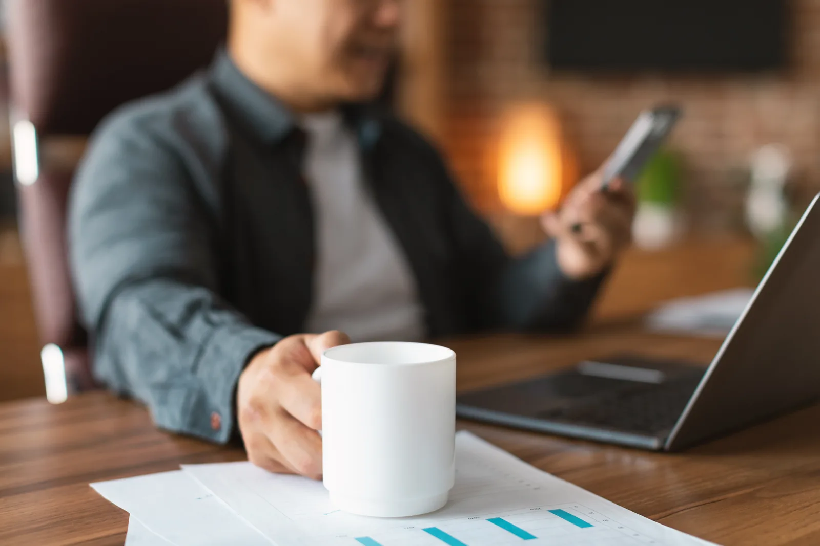 Manager reviews a support ticket dashboard on a desktop monitor beside a coffee mug